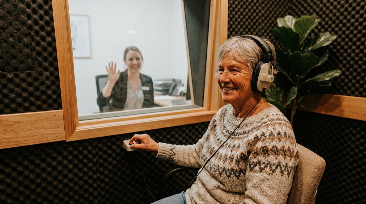 Audiometrist conducting a hearing test in a sound-treated booth